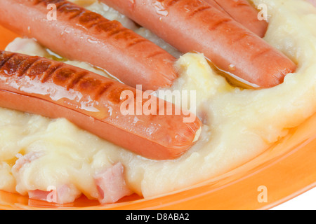 Salsicce con purea di patate nel piatto arancione Foto Stock