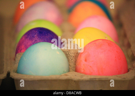 Una raccolta di uova di Pasqua colorate, disposte su una superficie piana. Le uova presentano una varietà di tonalità luminose e pastello, tipicamente utilizzate per la caccia all'uovo di Pasqua o come decorazioni festive durante le festività. I colori vivaci delle uova simboleggiano il rinnovamento e la celebrazione. Foto Stock