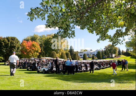 I giocatori di arrivare al loro carrelli appena prima il fucile da caccia inizia a un corporate golf tournament. Foto Stock