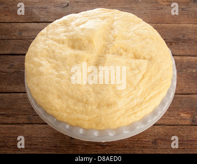 In aumento la pasta lievitata in ciotola sul tavolo di legno Foto Stock