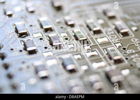 Vista ravvicinata di una scheda a circuito integrato, che mostra l'intricato design dei suoi percorsi, componenti e collegamenti. Questa tecnologia è essenziale nei moderni dispositivi elettronici. Foto Stock