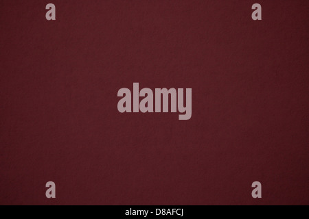 Un primo piano della trama della carta marrone, che mostra i colori intensi e profondi e la superficie liscia della carta. Il materiale appare testurizzato e può essere utilizzato in vari progetti artistici o di design. Foto Stock