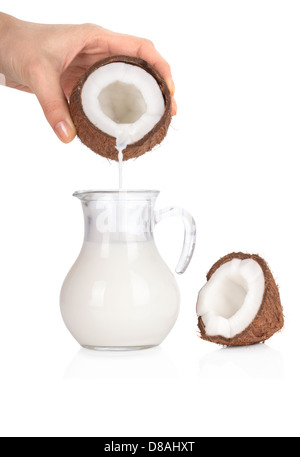Donna di mano versando il latte di cocco in una giara isolati su sfondo bianco Foto Stock