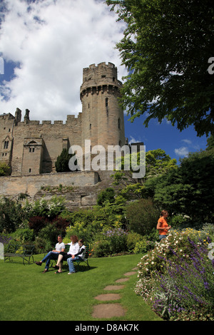 Turisti che si godono i giardini sotto il Castello di Warwick alla fine di Mill Street, dal castello mulino e il mulino stagno Foto Stock