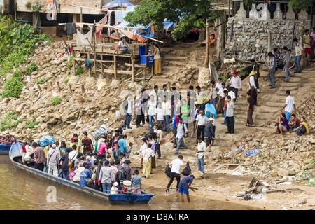 23 maggio 2013 - Mae Sot, Tak, Thailandia - La gente si affrettano verso l'alto e verso il basso le rive del fiume Moei in Myawaddy, Myanmar presso un non ufficiale valico di frontiera. Essi cram nella grande barca e galleggiante sul fiume. Cinquanta anni di sconvolgimenti politici in Birmania (Myanmar) ha portato milioni di birmani a lasciare il loro paese. Molti si sono insediati nella vicina Thailandia. Mae Sot, sulla Mae Nam Moie Moie (fiume) è il centro della giunta birmana emigre comunità nel centro ovest della Thailandia. Ci sono centinaia di migliaia di rifugiati birmani e migranti nella zona. Molti vivono un ombroso esistenza senza documenti Foto Stock