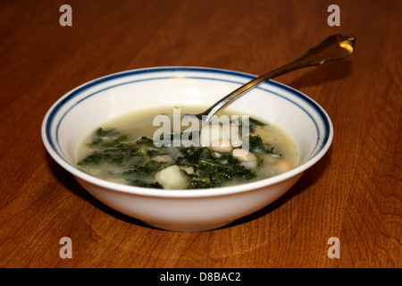 Un recipiente per la cottura a vapore di zuppa di cavoli di patate servito in un piatto semplice. La zuppa contiene pezzi di patate e cavolo fresco, creando un pasto sostanzioso e nutriente, spesso servito caldo. Foto Stock
