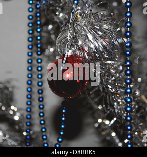 Varie decorazioni natalizie disposte su un tavolo, tra cui ornamenti, ghirlande e luci. Gli articoli per le feste sono stati progettati per creare un'atmosfera di vacanza gioiosa. Foto Stock