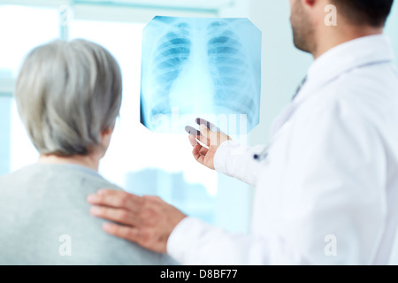Immagine di senior il paziente e il medico cerchi a raggi x in ospedale Foto Stock