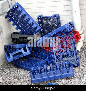 Un mucchio di casse di soda in plastica impilate insieme. Queste casse sono utilizzate per il trasporto e lo stoccaggio di bottiglie, comunemente presenti nei centri di distribuzione, nelle aree di vendita al dettaglio e nelle stazioni di riciclaggio. Foto Stock