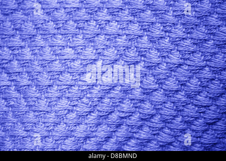 Vista ravvicinata di una coperta blu reale caratterizzata da un motivo a diamante. L'intricata trama della coperta crea un fascino visivo distinto, evidenziando la sua atmosfera morbida, accogliente e il design elegante. Foto Stock