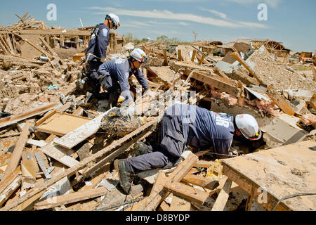 FEMA Urban squadre di ricerca e soccorso cerca casa per casa per i superstiti in un quartiere distrutto in seguito a un EF-5 tornado Maggio 22, 2013 in Moore, Oklahoma. La massiccia tempesta con venti che superano 200 miglia per ora tore attraverso l'Oklahoma City sobborgo Maggio 20, 2013, uccidendo almeno 24 persone e ferendone più di 230 e spostare migliaia. Foto Stock