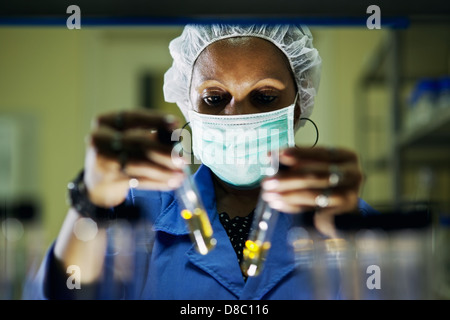 La scienza e la ricerca, la donna lavora come farmacista guardando alla provetta di test in laboratorio Foto Stock