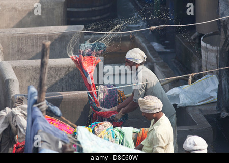 Un uomo di lavaggio a mano vestiti in Dhobi Ghat, un ben noto aperto lavanderia a gettoni in Mumbai, India Foto Stock