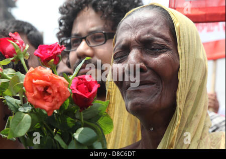 Savar, Dhaka, Bangladesh. Il 24 maggio 2013. Una famiglia bengalese membro di un indumento mancante lavoratore piange come ella rende omaggio alle vittime presso il sito di aprile 2013 Edificio di nove piani crollo in Savar, nella periferia di Dhaka il 24 maggio 2013. Alcuni 290 corpi non identificati sono stati sepolti dopo i campioni di DNA sono stati raccolti in modo che corrispondano a quelli di parenti come l'esercito del Bangladesh avvolto nella sua ricerca Maggio 14, 2013 per gli organismi presso il sito del crollo dell'edificio. Disastri industriali dal novembre hanno ucciso almeno 1.250 lavoratori. Â©Monirul Alam (credito Immagine: © Monirul Alam/ZUMAPRESS.com/Alamy L Foto Stock