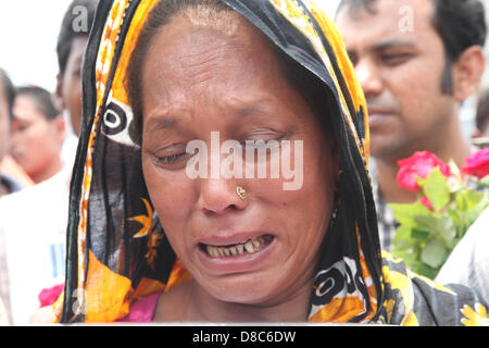 Savar, Dhaka, Bangladesh. Il 24 maggio 2013. Una famiglia bengalese membro di un indumento mancante lavoratore piange come ella rende omaggio alle vittime presso il sito di aprile 2013 Edificio di nove piani crollo in Savar, nella periferia di Dhaka il 24 maggio 2013. Alcuni 290 corpi non identificati sono stati sepolti dopo i campioni di DNA sono stati raccolti in modo che corrispondano a quelli di parenti come l'esercito del Bangladesh avvolto nella sua ricerca Maggio 14, 2013 per gli organismi presso il sito del crollo dell'edificio. Disastri industriali dal novembre hanno ucciso almeno 1.250 lavoratori. Â©Monirul Alam (credito Immagine: © Monirul Alam/ZUMAPRESS.com/Alamy L Foto Stock