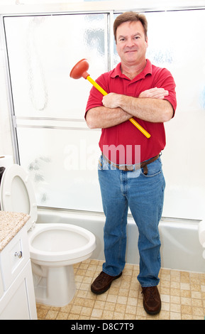 Plumber o proprietario tenendo un pistoncino e in piedi in un bagno moderno. Foto Stock