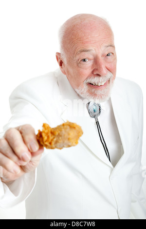 Bello southern senior gentleman, Kentucky colonel (un titolo generico), mangiare un fritto di pollo gamba. Sfondo bianco. Foto Stock