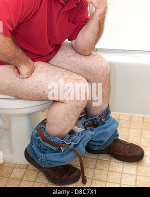 Closupe di un uomo pensare cose su seduti sul water. Foto Stock