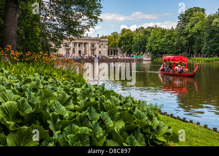 Il turista a godere di una gita in gondola sul lago del Parco di Łazienki Łazienkowski, più grande di Varsavia con il palazzo in background. Foto Stock