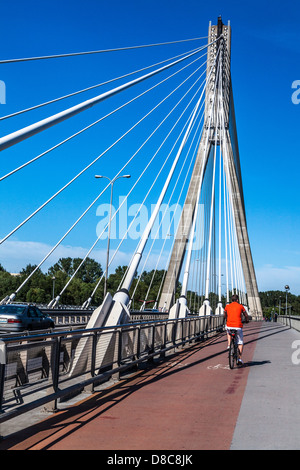 Un uomo di cicli attraverso la Świętokrzyski ponte sopra il fiume Vistola a Varsavia, un moderno sospeso con cavi di costruzione. Foto Stock