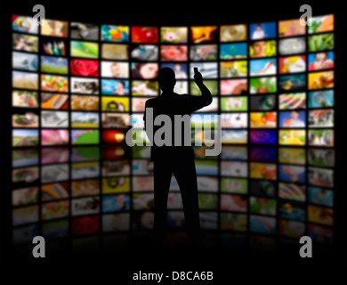 Vista posteriore di un giovane uomo di guardare un grande pannello TV Foto Stock