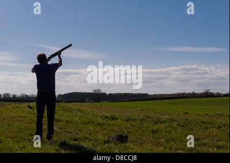 Una silhouette di un uomo ripresa piccioni di argilla con un fucile da caccia nel Regno Unito Foto Stock