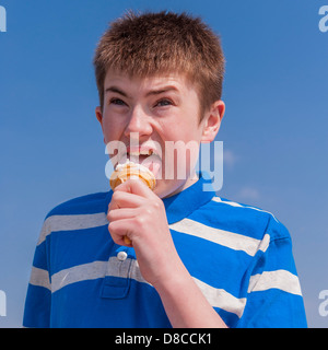 Un ragazzo di 13 anni di mangiare un gelato nel Regno Unito Foto Stock