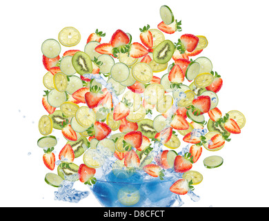 Assortiti fette di frutta caduta nel bicchiere riempito con acqua e ghiaccio. Isolato su sfondo bianco. Foto Stock