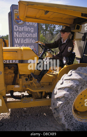 Lavoratrice donna che utilizza un veicolo con attrezzature di grandi dimensioni in un cantiere. L'immagine mette in evidenza il suo ruolo nella gestione di macchinari per progetti su larga scala, dimostrando le sue competenze nel lavoro industriale. Foto Stock