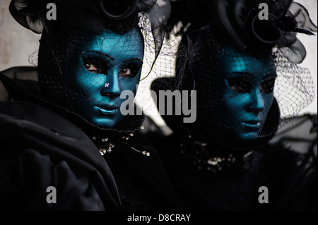 Due donne che indossano dark costumi di Carnevale e maschere durante il carnevale veneziano, Italia. Foto Stock