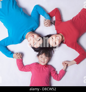 Famiglia tenendo le mani in un cerchio, shot direttamente sopra Foto Stock