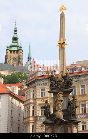 Scenico urbano di Praga con la colonna barocca di Santa Trinità di fronte la chiesa di San Nicola in Lesser Town Square Foto Stock