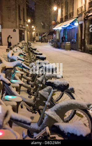 Coperta di neve Bici a Parigi stazione Velib. Foto Stock