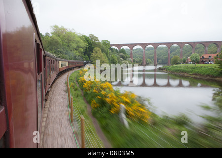 Convoglio ferroviario passando velocizzando la scena veloce ponte con calma ombra Foto Stock