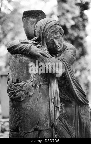 Statua di una donna triste sulla tomba del cimitero di Praga Foto Stock