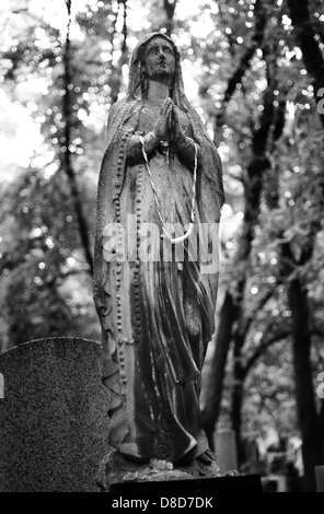 Una statua di una donna orante sul cimitero di Praga Foto Stock