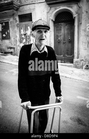 Uomo anziano richiede esercizio di La Valletta utilizzando un telaio a piedi Foto Stock