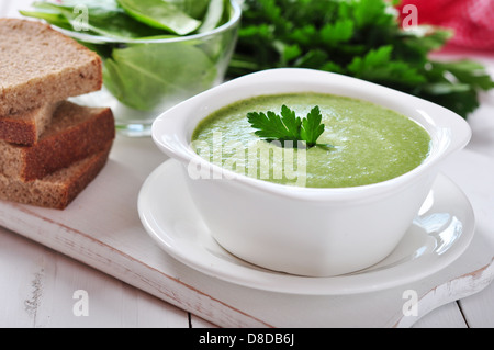 Zuppa di spinaci in una ciotola su uno sfondo di legno Foto Stock