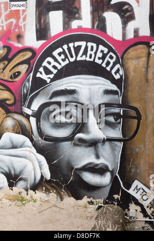 Street Art graffiti sulla parete a Kreuzberg Hip hop stile carattere maschio parlando al telefono con 'Kreuzberg' sul cappuccio Berlino Germania Foto Stock