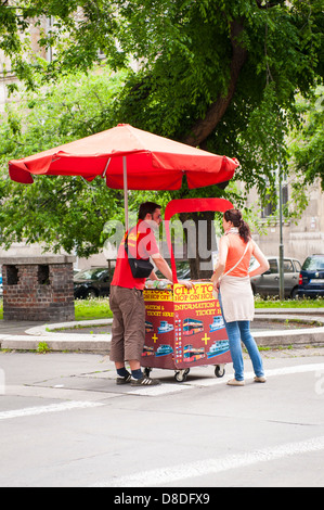 Ungheria Budapest City rosso tipico bus tour hop on hop off barrow carrello turistico punto vendita uomo donna ombrellone ombrellone ombrellone scene di strada Foto Stock