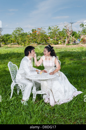 Asian Thai nuziale di alimentazione è il pezzo di torta di nozze al suo sposo in questo momento come il principe e la principessa. Foto Stock