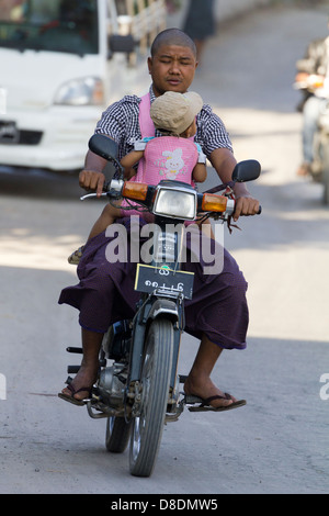 Caotico traffico stradale sulle strade di Mandalay, Myanmar 3- sleepy ciclomotore rider con baby Foto Stock