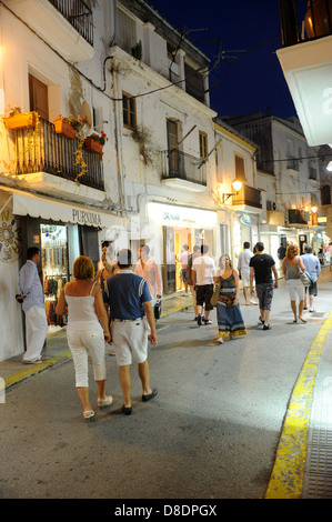 I vacanzieri passeggiata attraverso le strade della città di Ibiza di notte Foto Stock