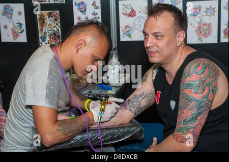 Londra, UK, 26 maggio 2013. Tattooist Beynur Kaptan, 32, (sinistra) originariamente dalla Turchia, ora in Littleport, Cambridgeshire, funziona su un tatuaggio per Nikita Yefimov, 42, da Mosca. Credito: Terence Mendoza/Alamy Live News Foto Stock