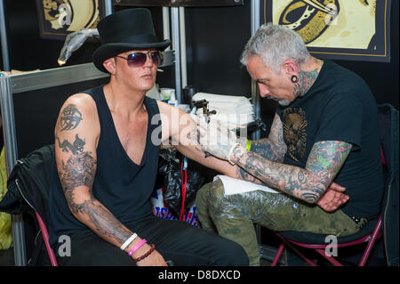 Londra, UK, 26 maggio 2013. Tattooist Sean Vasquez (a destra), 51, precedentemente da Brooklyn, NY, ora in Leytonstone, Londra, funziona su un tatuaggio per David Harris, 38, che è a tempo pieno un padre. Credito: Terence Mendoza/Alamy Live News Foto Stock