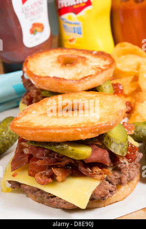 Il Luther burger: una polpetta di carne, formaggio, pancetta croccante e cetriolini tra due metà di un anello di vetrata a ciambella. Foto Stock