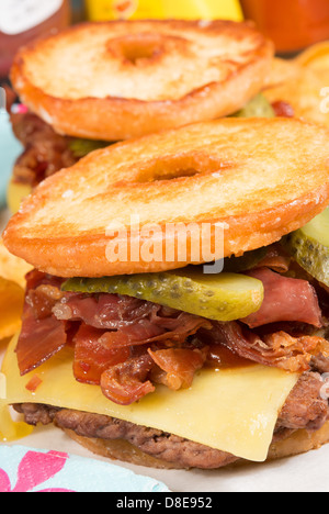 Il Luther burger: una polpetta di carne, formaggio, pancetta croccante e cetriolini tra due metà di un anello di vetrata a ciambella. Foto Stock