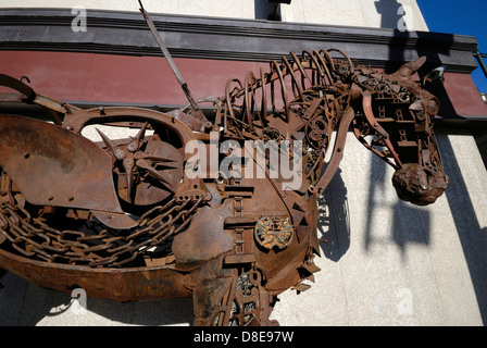 Una scultura a cavallo realizzata interamente con parti riciclate di macchinari agricoli saldate insieme e situata in un angolo di strada nel centro di Calgary, Alberta Foto Stock