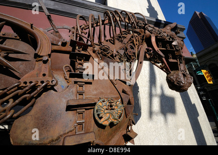 Una scultura a cavallo realizzata interamente con parti riciclate di macchinari agricoli saldate insieme e situata in un angolo di strada nel centro di Calgary, Alberta Foto Stock