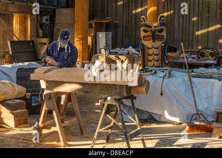 Carver in totem carving shed, Granville Island, Vancouver, British Columbia, Canada Foto Stock